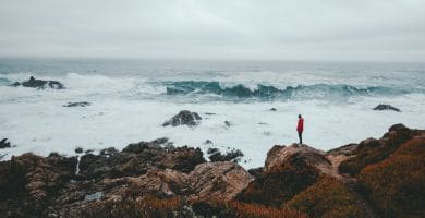 Thinking big in 2022 3 pensar a lo grande, thinking big, think big man standing on brown rock formation beside seashore during daytime