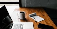 Profitable blog, MacBook Pro, white ceramic mug,and black smartphone on table