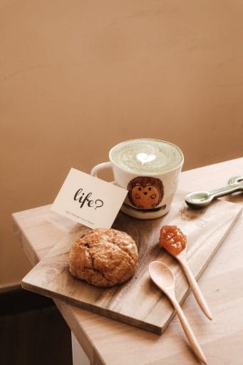 franchisees for life. white ceramic mug beside brown cookies on brown wooden chopping board