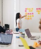 marketing plan, woman placing sticky notes on wall