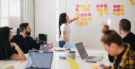 marketing plan, woman placing sticky notes on wall