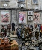 trade fairs clothes and bags displayed on road near building during daytime